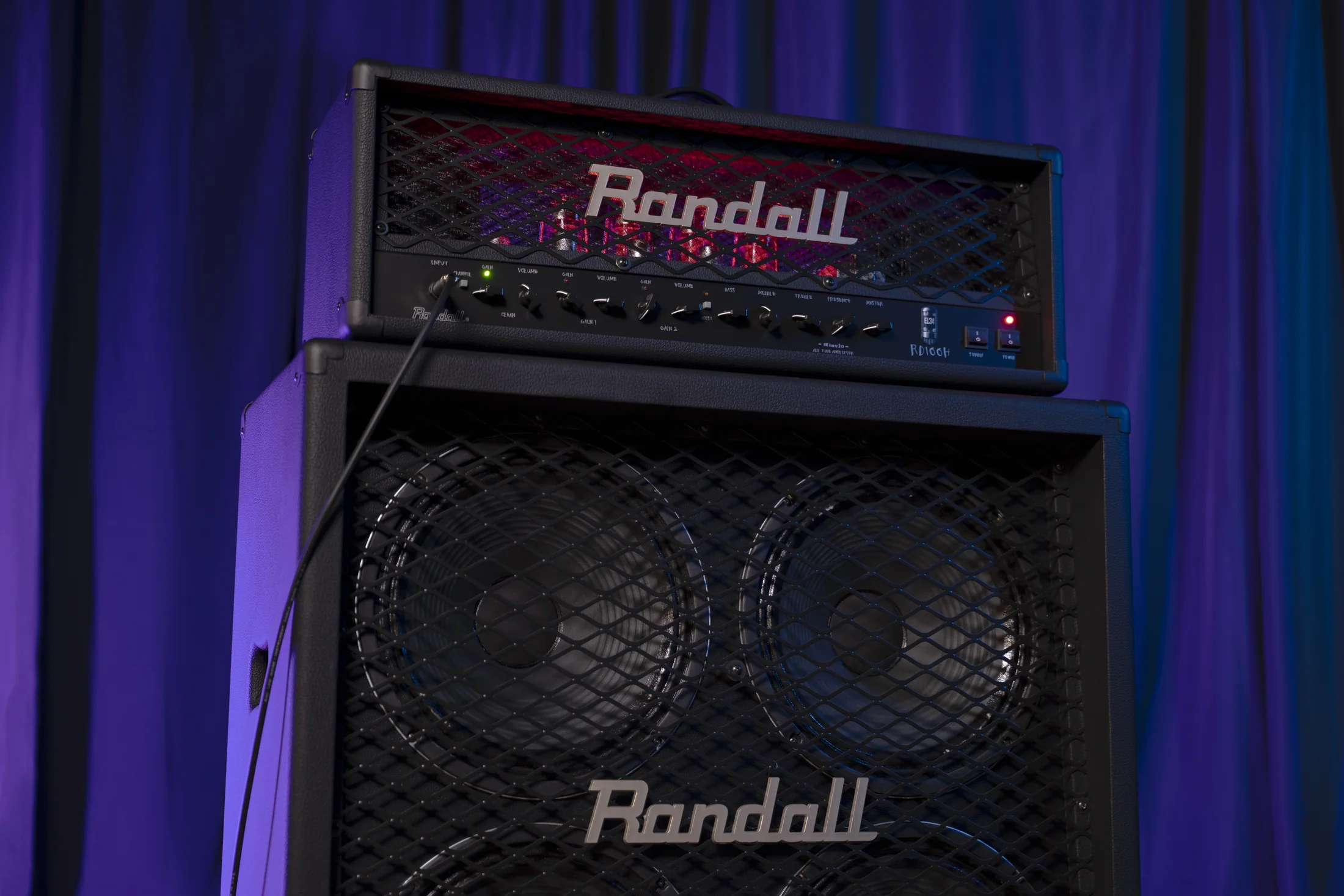 Randall RD100 amplifier head and speaker cabinet on a purple-lit stage